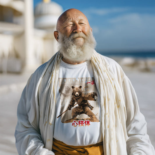 Weißes T-Shirt von GOGOJIFAM mit dem Motiv JŌDŌ BEAR: Ein Braunbär-Wandermönch mit Long Stick in Kampfposition. Im Hintergrund erscheint sein Meister aus der Vergangenheit. Das ausdrucksstarke Design im Manga-Stil betont die Kultivierung alten Wissens, die Verbundenheit aller Dinge - und den Kampf der Tiere um ihre Existenz. Ein kreatives Statement für Umwelt- und Tierschutz.